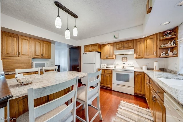 kitchen with white appliances, a textured ceiling, decorative light fixtures, dark wood-type flooring, and light stone counters