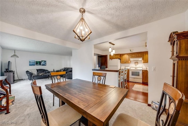 carpeted dining space featuring a textured ceiling and a notable chandelier