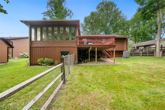 rear view of property featuring a sunroom, a lawn, and central air condition unit