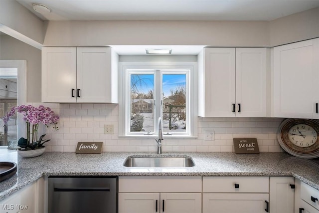 kitchen with dishwashing machine, sink, decorative backsplash, and white cabinets