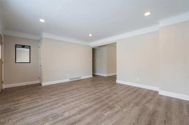 unfurnished room featuring hardwood / wood-style floors and crown molding