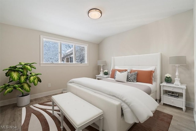 bedroom featuring light wood-type flooring and vaulted ceiling