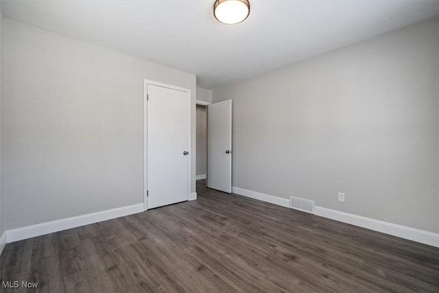 unfurnished room featuring dark wood-type flooring