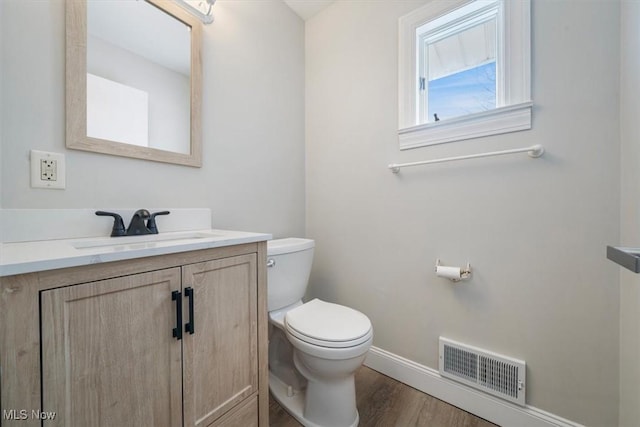 bathroom with wood-type flooring, toilet, and vanity