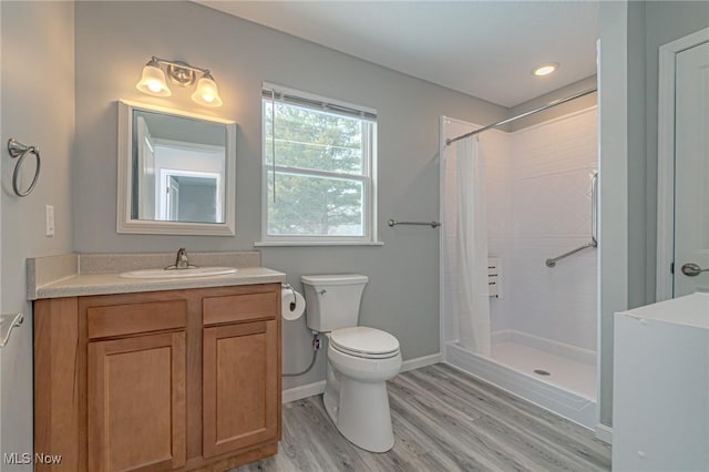 bathroom featuring a shower with curtain, hardwood / wood-style flooring, toilet, and vanity