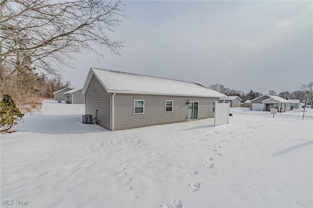 snow covered house with central air condition unit