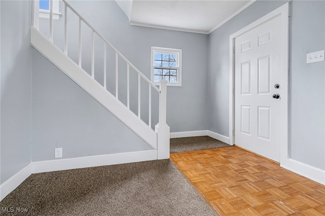 entrance foyer with crown molding and light parquet flooring