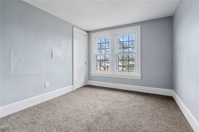 carpeted empty room with a textured ceiling