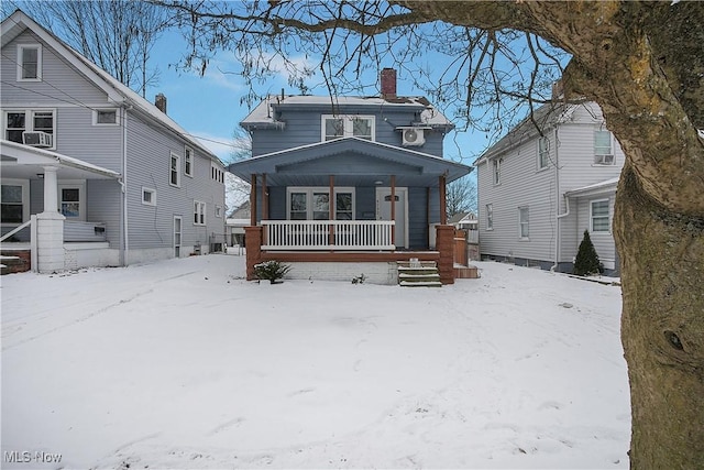 snow covered property with a porch