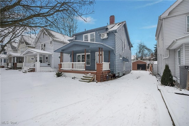 front of property featuring covered porch and a storage shed