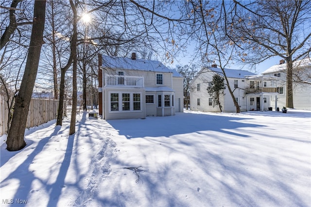 snow covered house featuring a balcony