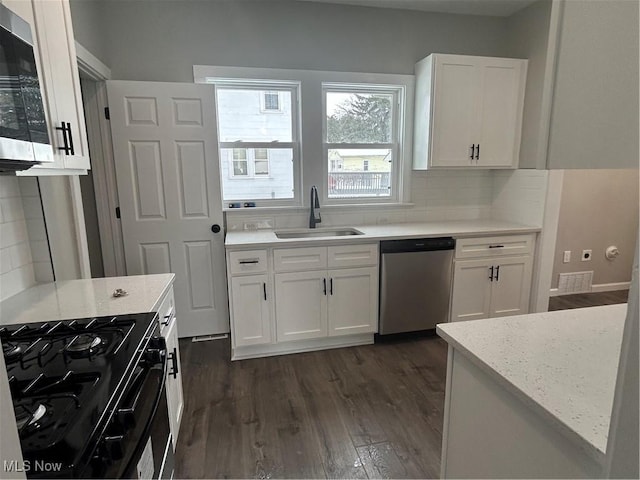 kitchen featuring tasteful backsplash, sink, white cabinets, stainless steel appliances, and light stone counters