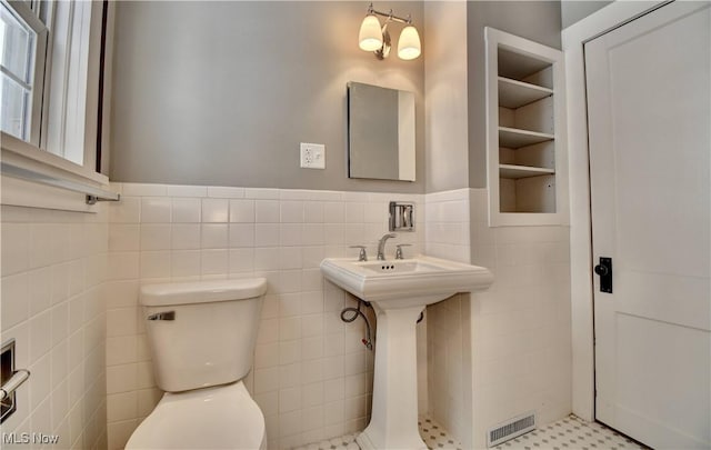 bathroom featuring tile patterned floors, tile walls, and toilet