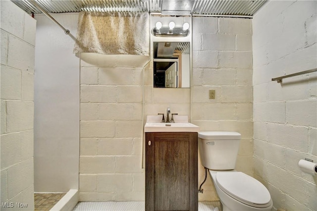 bathroom featuring toilet, walk in shower, and vanity