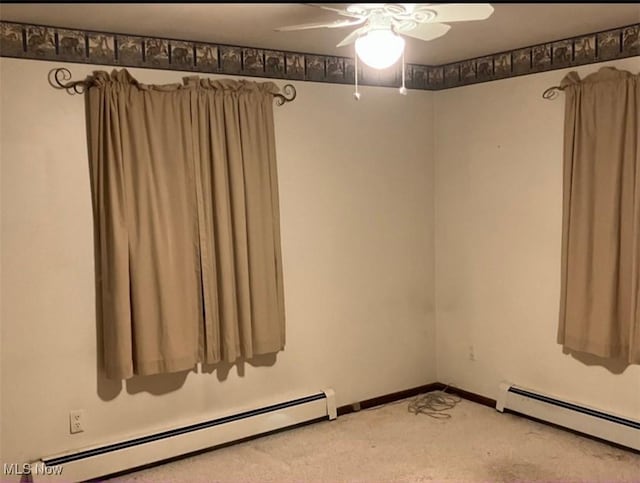 carpeted empty room featuring ceiling fan and a baseboard heating unit