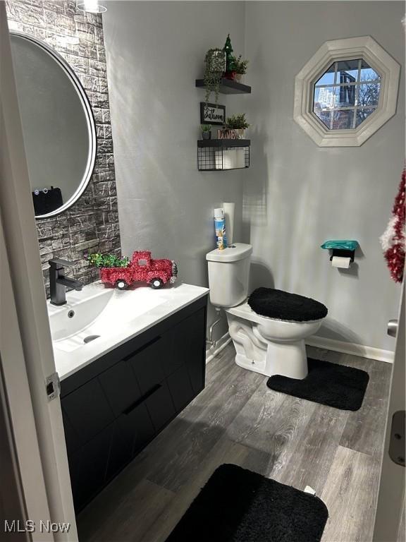 bathroom with vanity, toilet, and wood-type flooring