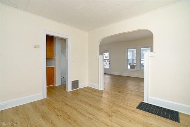 unfurnished room featuring ornamental molding and light wood-type flooring