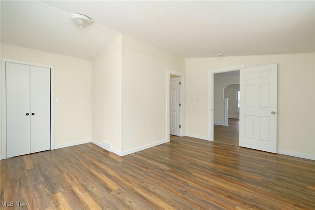 unfurnished room with vaulted ceiling and dark hardwood / wood-style floors