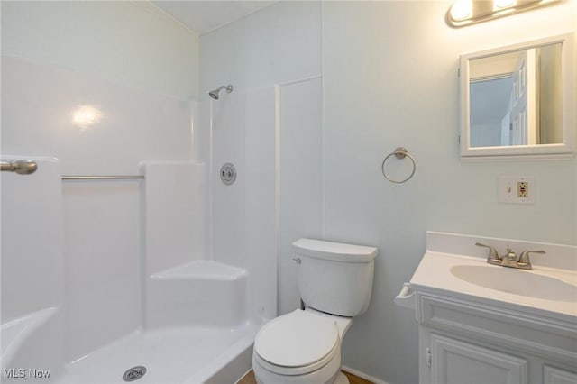 bathroom with walk in shower, vanity, and toilet