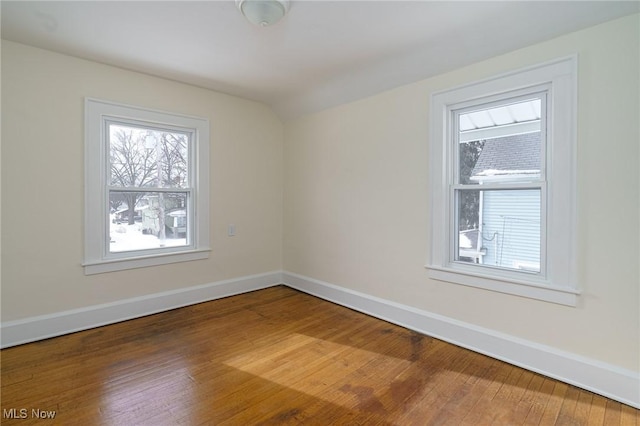 empty room featuring vaulted ceiling and wood-type flooring