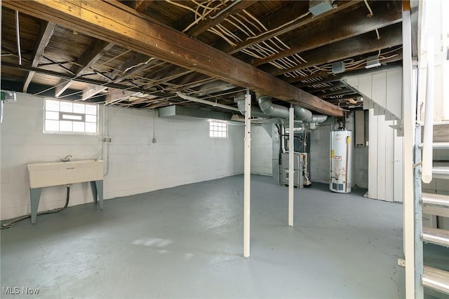 basement featuring heating unit, sink, and gas water heater