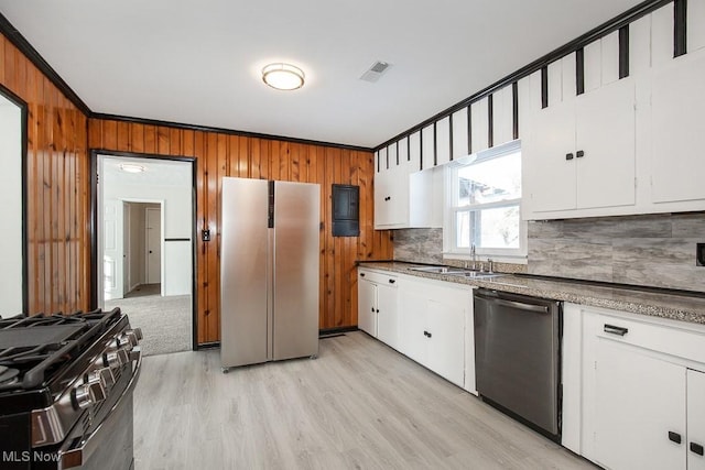 kitchen featuring white cabinets, appliances with stainless steel finishes, light hardwood / wood-style floors, sink, and crown molding