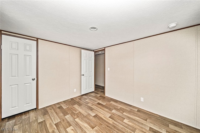 basement featuring a textured ceiling and light hardwood / wood-style flooring