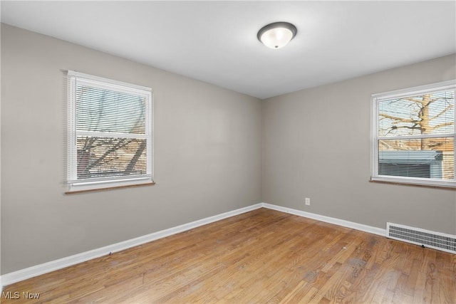 empty room with a healthy amount of sunlight and light hardwood / wood-style floors