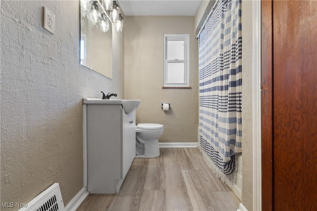 bathroom with a shower with curtain, hardwood / wood-style flooring, toilet, and vanity