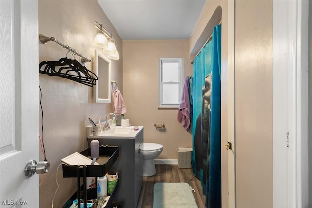 bathroom with hardwood / wood-style flooring, toilet, and vanity