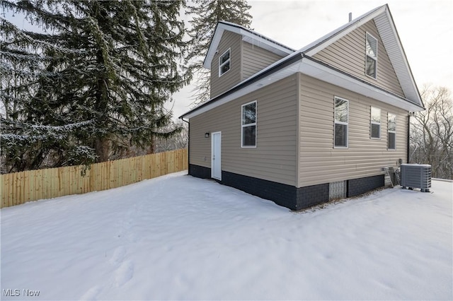 snow covered property featuring central AC unit