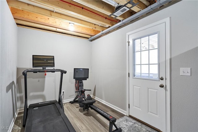 exercise room with light hardwood / wood-style floors