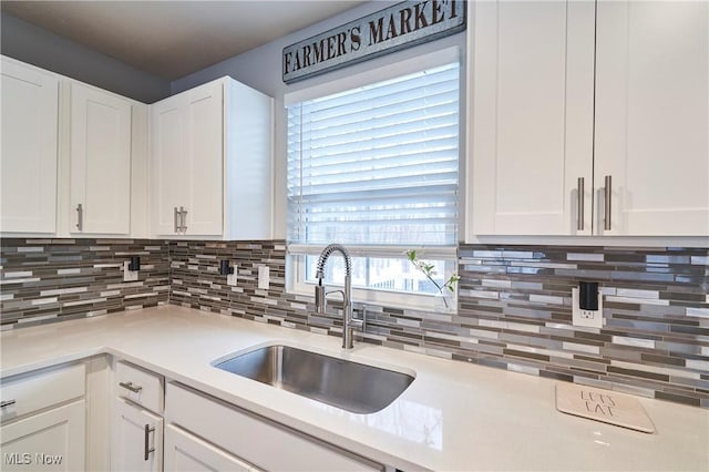 kitchen with sink, white cabinetry, and decorative backsplash