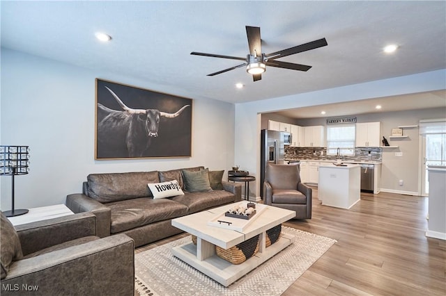 living room featuring light hardwood / wood-style flooring and ceiling fan