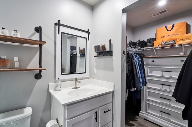 bathroom with hardwood / wood-style floors, toilet, and vanity