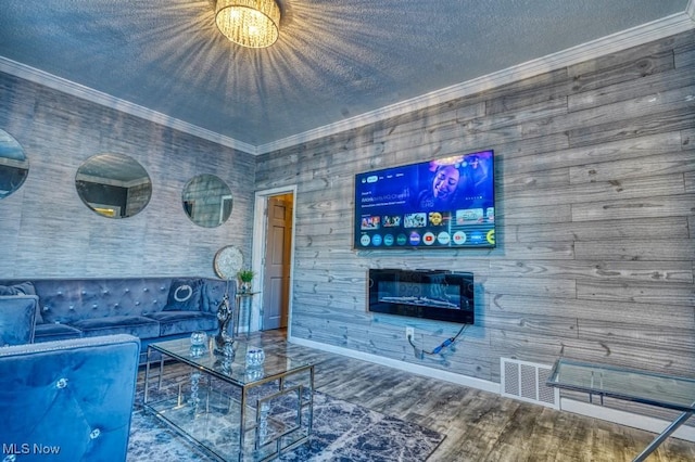 living room with wood-type flooring, crown molding, and a textured ceiling