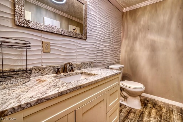 bathroom with hardwood / wood-style flooring, toilet, vanity, and ornamental molding