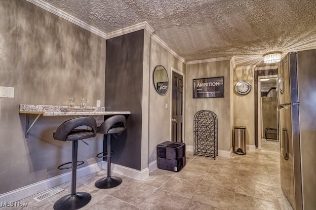 interior space with refrigerator, light stone countertops, and ornamental molding