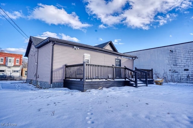 snow covered property with a wooden deck