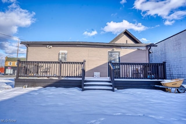 snow covered property with a wooden deck