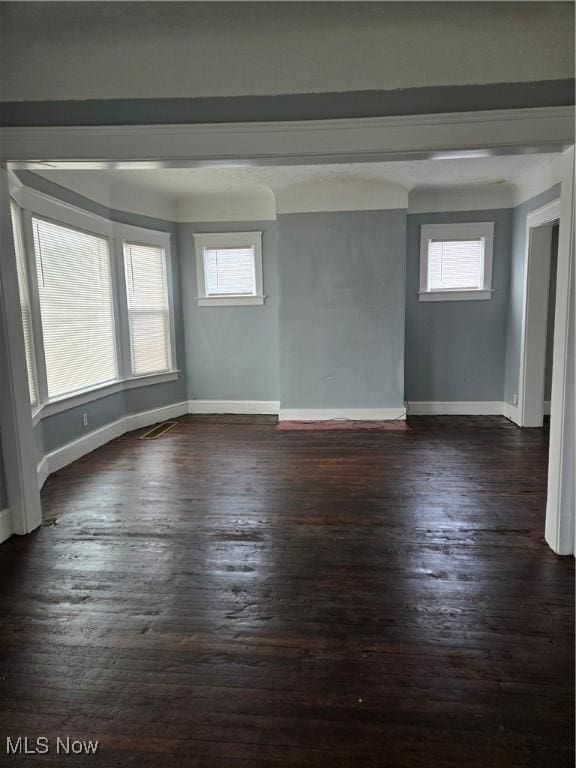 unfurnished room with a wealth of natural light and dark wood-type flooring