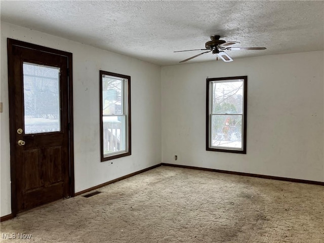 carpeted foyer with ceiling fan and a textured ceiling