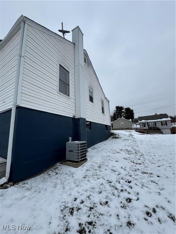 view of snow covered exterior with central AC