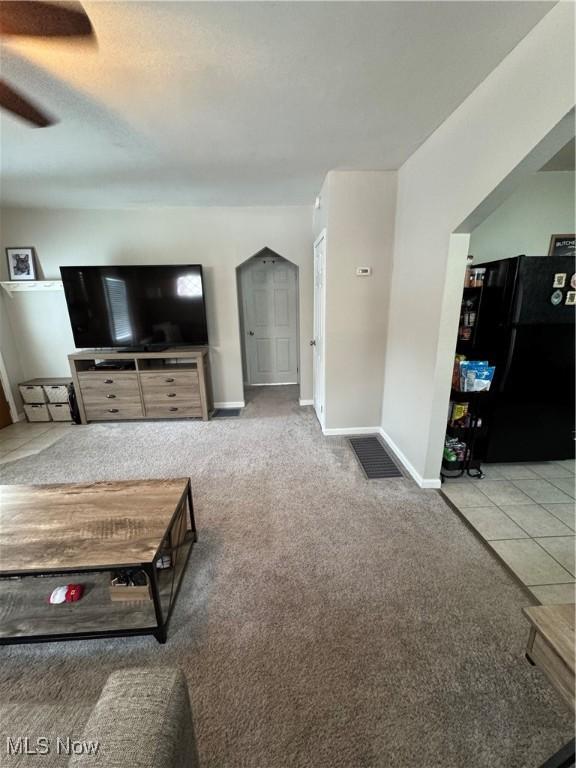 unfurnished living room featuring carpet floors and ceiling fan