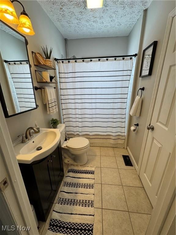 bathroom with tile patterned floors, a textured ceiling, toilet, and vanity