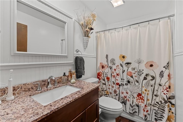 bathroom with crown molding, toilet, walk in shower, and vanity