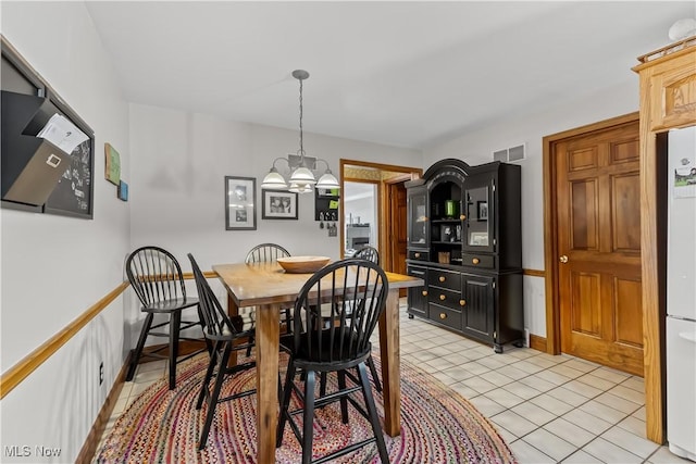 dining space featuring light tile patterned floors and a notable chandelier