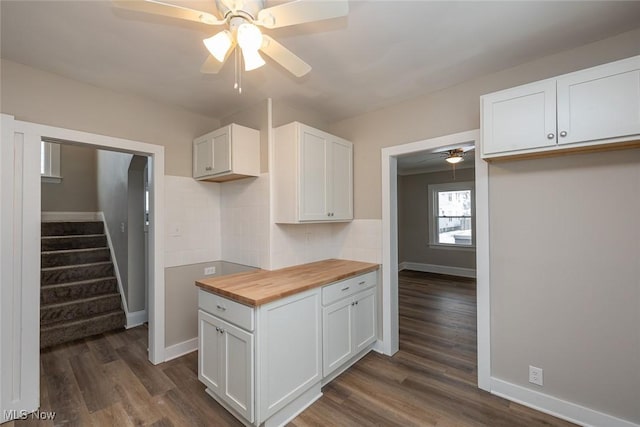 kitchen featuring dark wood-style floors, backsplash, ceiling fan, and butcher block counters