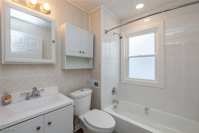 bathroom with shower / bath combination, toilet, tile walls, and vanity