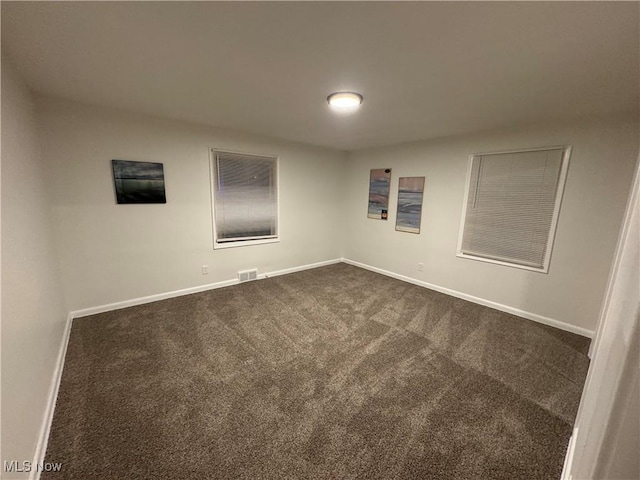 empty room featuring dark carpet